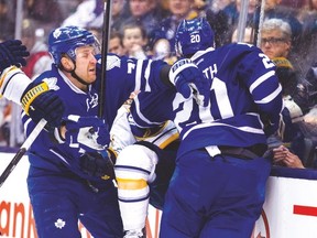 Leafs’ Leo Komarov and David Booth collide with a Buffalo Sabre during Wednesday night’s game. (ERNEST DOROSZUK/Toronto Sun)