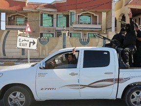 Sunni tribal fighters ride in a vehicle with their weapons as they guard against possible attacks from Islamic State militants, in Ramadi, west of Baghdad, March 11, 2015.  REUTERS/Ali al-Mashhadani