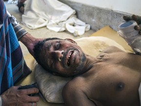 A Bangladeshi survivor of the collapse of a partly-built cement factory in southern Mongla town, lies on the floor of a hospital in Khulna on March 12, 2015.  The roof of a partly-built cement factory collapsed in southern Bangladesh, killing at least four workers and dozens others feared trapped under the debris, police and rescuers said.  AFP PHOTO / SHAIKH MOHIR UDDIN