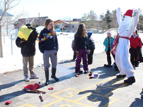 Bonhomme de neige does a victory dance as he scores the highest point during the beanbag toss.