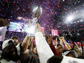 Members of the New England Patriots celebrate with the Vince Lombardi Trophy after defeating the Seattle Seahawks 28-24 in Super Bowl XLIX at University of Phoenix Stadium on February 1, 2015 in Glendale, Arizona. (Christian Petersen/Getty Images/AFP)