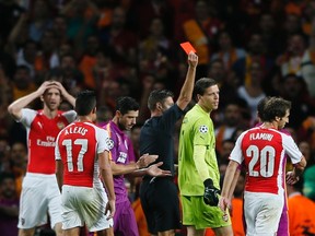 Arsenal goalkeeper Wojciech Szczesny (second from right) is shown a red card by referee Gianluca Rocchi during Champions League play against Galatasaray at the Emirates Stadium in London October 1, 2014. (REUTERS/Stefan Wermuth)