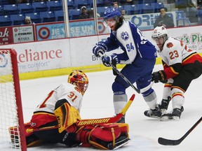 Brody Silk, middle, of the Sudbury Wolves, attempts to fire a puck past Charlie Graham, of the Belleville Bulls, during OHL action at the Sudbury Community Arena in Sudbury, Ont. on Friday March 6, 2015.  (QMI Agency)