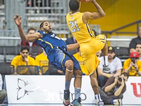 Ryerson Rams’ Adika Peter-McNeilly sends  Bradford Parker of the Windsor Lancers flying as he goes up with the basketball during their CIS Final 8 game last night at the Mattamy Athletic Centre. The Rams won the physical battle 82-68 to advance to Saturday’s semifinal versus Ottawa. (ERNEST DOROSZUK, Toronto Sun)