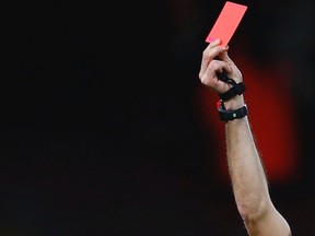 A referee holds up a red card. (Eddie Keogh/Reuters/Files)