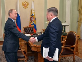 Russian President Vladimir Putin, left, shakes hands with Supreme Court chairman Vyacheslav Lebedev during their meeting at the Novo-Ogaryovo state residence outside Moscow March 13, 2015. Russian state television broadcast footage which it said was of Putin meeting Lebedev on March 13 at Putin's residence near Moscow.  ( REUTERS/Alexei Druzhinin/RIA Novosti/Kremlin)