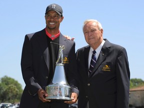 Tiger Woods holds the trophy as he stands with golf legend Arnold Palmer after he won the Arnold Palmer Invitational in Orlando, Fla. on March 25, 2013.  (Scott Miller/Reuters/Files)