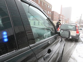 OPP Const. Gregory Bell speaks to a driver spotted using a handheld device while driving on Hwy. 417 during a patrol Friday morning. A major OPP-Ottawa police distracted driving campaign launches Saturday.DOUG HEMPSTEAD/Ottawa Sun