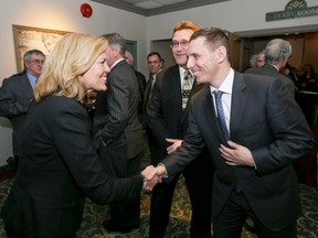Ontario PC leadership candidate Whitby-Oshawa MPP Christine Elliott, left, is greeted by fellow PC leadership candidate Barrie MP Patrick Brown, right, and Bruce-Grey-Owen Sound MPP Bill Walker, 2nd right, as she arrives for the Bruce-Grey-Owen Sound Provincial PC Association dinner at the Days Inn in Owen Sound, Ont. on Friday, March 6, 2015. The pair were invited guest at the fundraising dinner. Each candidate was invited to deliver a speech and to answer questions from riding members. (QMI Agency)