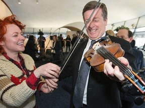 Mayor John Tory gets a violin lesson from Miranda Mulholland from the band Great Lake Swimmers at City Hall on March 13, 2015. (Craig Robertson/Toronto Sun)