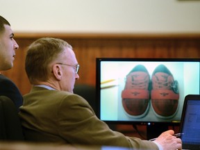 Former New England Patriots player Aaron Hernandez (left) and his attorney, Charles Rankin, look at an exhibit on a monitor during his murder trial in Fall River, Mass., March 13, 2015. (REUTERS/Ted Fitzgerald/Pool)