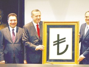 Turkish Prime Minister Recep Tayyip Erdogan, left, and Central Bank Governor Erdem Basci presents the new symbol for  the national currency, the Turkish lira, in 2012. Three years later, the two men are in a battle over interest rates. (Adem Altan/AFP Photo)