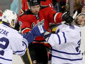 Calgary Flames' David Jones jostles with Maple Leafs' T.J. Brennan on March 13. (Mike Drew, QMI Agency)
