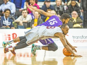 Bishop’s Gaiters’ Karim Sy-Morissette and Johnny Berhanemeskel of the Ottawa Gee-Gees dive for a loose ball during their opening game on Thursday. The Gaiters had the fan support but the Gee-Gees pulled out the win in overtime. (ERNEST DOROSZUK, Toronto Sun)