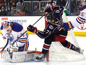 Columbus Blue Jackets Nick Foligno attempts to knock the puck out of the glove of Oilers goalie Ben Scrivens Friday night. (USA TODAY SPORTS)