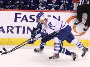 Vancouver Canucks' Derek Dorsett (behind) and Toronto Maple Leafs’ Tyler Bozak (front) battle for the puck  during the third period in Vancouver on Saturday night. (Carmine Marinelli/QMI Agency)