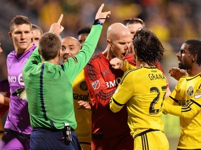Toronto FC’s Michael Bradley and the Crew’s Hernan Grana argue as referee David Gantar attempts to make a call on an illegal tackle in the first half in Columbus last night. Bradley and Gantar have a history of not agreeing on calls. (afp)
