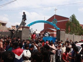 People and rescuers gather outside a church after a suicide attack in Lahore March 15, 2015. Bombs outside two churches in the Pakistani city of Lahore killed 14 people and wounded nearly 80 during Sunday services, and witnesses said quick action by a security guard prevented many more deaths.  A Pakistani Taliban splinter group claimed responsibility.  REUTERS/Mohsin Raza