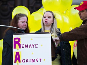 Renaye Wade, centre, speaks as her mother, Tammy Wade, left, and father, Darren Wade, right, offer support during a rally at the Alberta Legislature to mark the two-year anniversary of Renaye’s 
accident. (CODIE MCLACHLAN/EDMONTON SUN)
