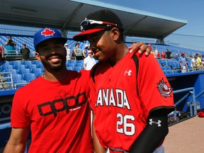 Dalton Pompey of the Blue Jays (left) throws an arm around his big little brother, Tristan, yesterday at Dunedin. Dalton’s Jays beat Tristan’s Canadian junior team 17-3 in the exhibition contest. The Pompeys parents were at the game.(STAN BEHAL/TORONTO SUN)