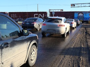 Cars wait for a CN train to pass on Waverley Street near Taylor Avenue last Friday. (Kevin King/Winnipeg Sun)