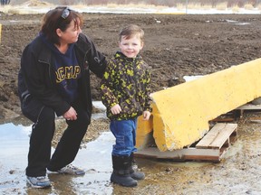 Nicole Fuhrer and her three-year-old grandson Oscar stand beside one of four catch basins covered only by wooden pallets until the Drayton Valley Public Works Department placed concrete barriers over top of them before proper grates could be installed.