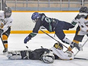 Keegan Dobbs of Durham CYO goes airborne over Mitchell Pee Wee AE goalie Greg Reidy during action from Game 1 of their OMHA Group 4 AE final series last Saturday. Curtis Chaffe (16) and Evan MacArthur (18) look on. The Meteors took a 2-0 series lead in the best-of-five affair with a pair of home ice wins this past weekend, and look to end the series and win the provincial championship on the road this weekend. KRISTINE JEAN/MITCHELL ADVOCATE