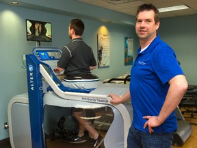 Bill Landry, of the Family Physiotherapy Centre of London, shows how their anti-gravity treadmill uses air pressure to support up to 80% of a person?s weight during therapy. (Mike Hensen, The London Free Press)