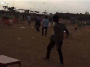 Screen shot from a video that shows a boy plummeting to the ground after being caught in a large kite in Vietnam. (LiveLeak)