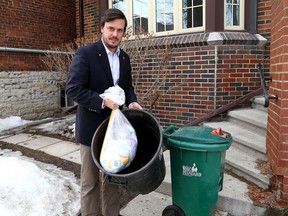 Sydenham District councillor Peter Stroud gets his garbage ready for pickup on Monday in front of his Bagot Street home. (Ian MacAlpine/The Whig-Standard/)