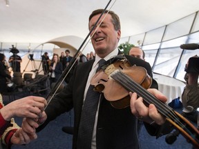 Mayor John Tory gets a violin lesson in Toronto Friday March 13, 2015 while promoting his trip to Austin, Texas. (Craig Robertson/Toronto Sun)