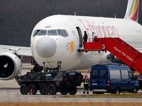 A police vehicle guards in front of the hijacked Ethiopian Airlines flight ET 702 after passengers disembarked at Cointrin Airport in Geneva on Feb. 17, 2014. (REUTERS/Denis Balibouse)