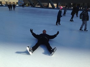 Mayor John Tory pretends to fall on the Nathan Phillips Square ice rink on Friday, February 20, 2015, after announcing a plan to keep some outdoor ice rinks open. (DON PEAT/Toronto Sun)