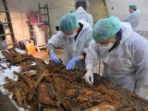 Experts examine the remains of coffins at a table inside the crypt of Madrid's Trinitarian convent in this handout picture released by Madrid's City Hall on Jan. 26, 2015. Researchers are undergoing the second phase of a project to find the remains of Spanish novelist Miguel de Cervantes, the creator of "Don Quixote", who requested to be buried in the convent. (REUTERS/Madrid City Hall/Sociedad Aranzadi)