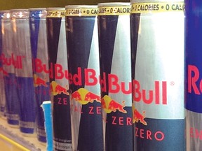 Cans of Red Bull energy drink sit on a shelf