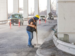 A worker sweeps away debris chipped away from the Gardiner Expressway between Cherry St. and the Don Valley Parkway in Toronto Tuesday March 17, 2015. (Ernest Doroszuk/Toronto Sun)