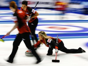 Canada's skip Jennifer Jones delivers a stone as her teammates Dawn McEwen and Jill Officer prepare to sweep during their curling round robin game against the U.S. at the World Women's Curling Championships in Sapporo March 17, 2015. (REUTERS/Thomas Peter)
