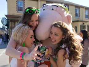 Sam Tinus, Colleen Cranford and Kash Yeck pose for a photo with Little Caesar outside of Little Caesars pizza shop on Central Avenue at Richmond Street in London, Ontario on Tuesday March 17, 2015.  Aside from joining fellow St. Patrick's Day revellers downtown, the trio were out celebrating Yeck's 20th birthday. (CRAIG GLOVER, The London Free Press)