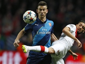 Monaco's Nabil Dirar (right) vies with Arsenal's Laurent Koscielny during Champions League play on March 17, 2015 at Louis II stadium in Monaco. (AFP PHOTO / VALERY HACHE)