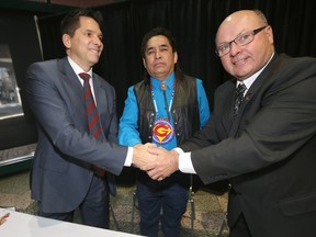 From the left; James Wilson, Treaty Commissioner, Sapotaweyak Cree Nation Chief, and President of the TLEC,  Nelson Genaille, and Doug Dobrowolski, President of AMM .  The three shake hands after a signing ceremony in Winnipeg Tuesday, March 17, 2015.
