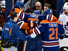 Matt Fraser is helped off the ice Monday after being hit by Maple Leafs Nazem Kadri. (Codie McLachlan, Edmonton Sun)