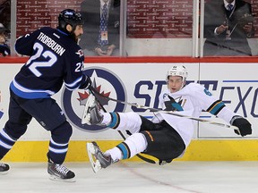 Winnipeg Jets right winger Chris Thorburn (l) dumps San Jose Sharks defenceman Justin Braun during NHL hockey in Winnipeg, Man. Tuesday, March 17, 2015.
Brian Donogh/Winnipeg Sun/QMI Agency