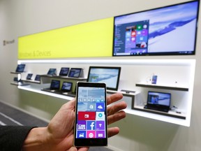A Microsoft representative holds a Windows smartphone with Windows 10 operating system in front of other devices with Windows 10 at the CeBIT trade fair in Hanover March 14, 2015. REUTERS/Morris Mac Matzen