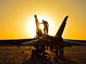 Royal Canadian Air Force ground crew perform post flight checks on a CF-18 fighter jet from 4 Wing Cold Lake, Alberta in Kuwait after a sortie over Iraq during Operation IMPACT on November 3, 2014. Canadian Forces Combat Camera, DND