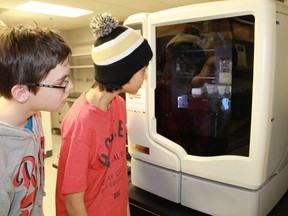 St. Clair Catholic District School Board students Ryan Vagley and Shogo Gudz, both 12, take a gander inside a 3-D printer at the Bluewater Technology Access Centre at Western Sarnia Lambton Research Park.
CARL HNATYSHYN/SARNIA THIS WEEK/QMI AGENCY