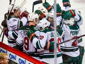 Minnesota Wild centre Mikko Koivu (9) celebrates his goal with teammates against the Calgary Flames during the overtime period at Scotiabank Saddledome. (Sergei Belski-USA TODAY Sports)