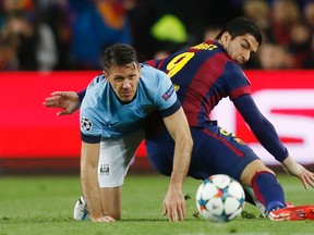 Manchester City's Martin Demichelis gets tangled up with Barcelona's Luis Suarez during Champions League play at the Nou Camp in Barcelona Wednesday, March 18, 2015. (Reuters/Carl Recine)