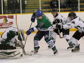 Jacob Bonin, middle, of the Sudbury Nickel Barons, tries to jam the puck past A.J. Smith, of the Elliot Lake Wildcats, during NOJHL playoff action at McClelland Arena in Copper Cliff on Wednesday March 18, 2015.