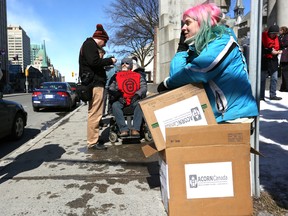 Abby Seward-Munday sits in cardboard boxes at a demonstration held by Ottawa Association of Community Organizations for Reform Now held at the corner of Elgin and Lisgar Streets Wednesday, Mar. 18, 2015. The group is pushing the provincial government for a 20 per cent raise in housing allowance afforded by social assistance. 
Andrew Meade/Ottawa Sun