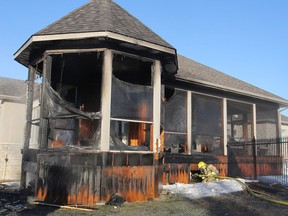 A firefighter hoses down a hot spot under a deck behind a home on Cordukes Road that caught fire Thursday morning following an attempt to thaw out the lines of a hot tub. THURS., MAR 19, 2015 KINGSTON, ONT. MICHAEL LEA THE WHIG STANDARD QMI AGENCY